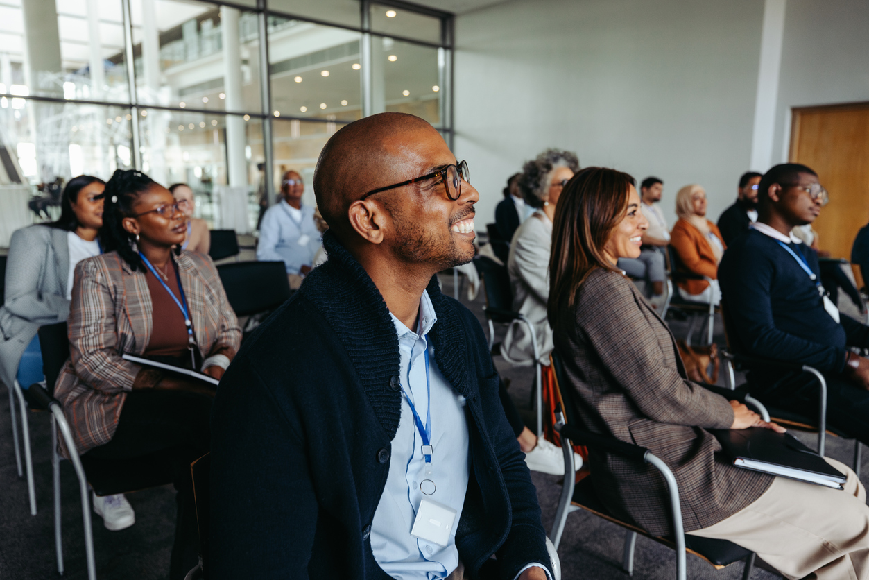 Team of businesspeople smiling at the camera in a boardroom Professional male engaging in a conference presentation